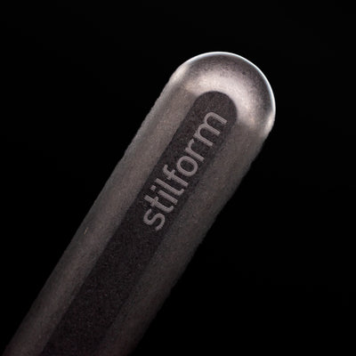 A macro shot of the logo on the bottom of the body of the Stilform INK Fountain Pen – Titanium DLC.