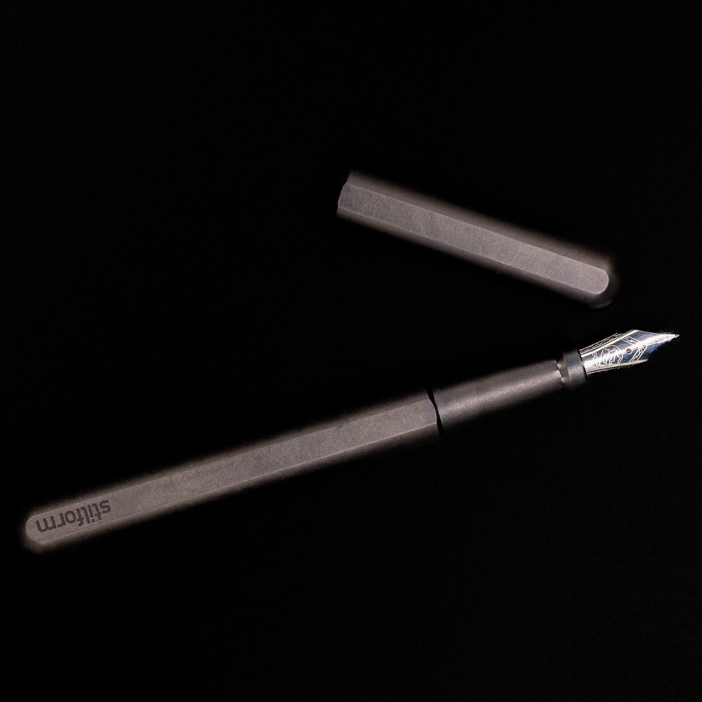 An overhead view of the Stilform INK Fountain Pen – Titanium DLC uncapped.