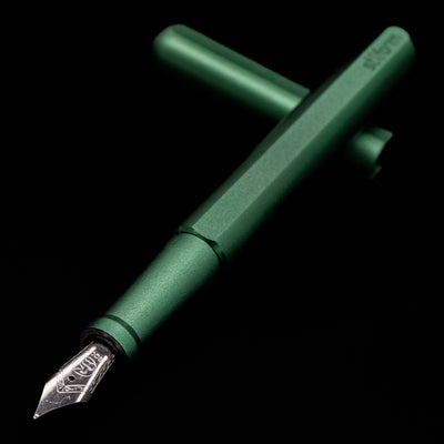Stilform INK Fountain Pen – Aurora Green Aluminum laying across its own cap, crossed, with a focus on the nib.