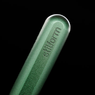 A macro shot of the logo on the bottom of the body of the Stilform INK Fountain Pen – Aurora Green Aluminum.