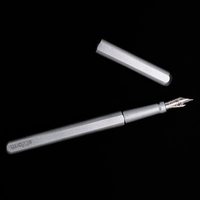 An overhead view of the Stilform INK Fountain Pen – Comet Grey Aluminum uncapped.