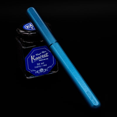 Stilform INK Fountain Pen – Night Sky Aluminum capped, leaning against an ink bottle. 