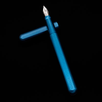 Stilform INK Fountain Pen – Night Sky Aluminum laying on top of its cap in a crossed position showing full view of the entire uncapped pen.