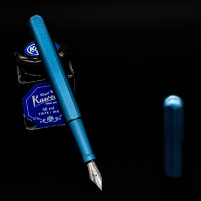 Stilform INK Fountain Pen – Night Sky Aluminum leaning on an ink bottle uncapped showcasing the detailing on the nib.