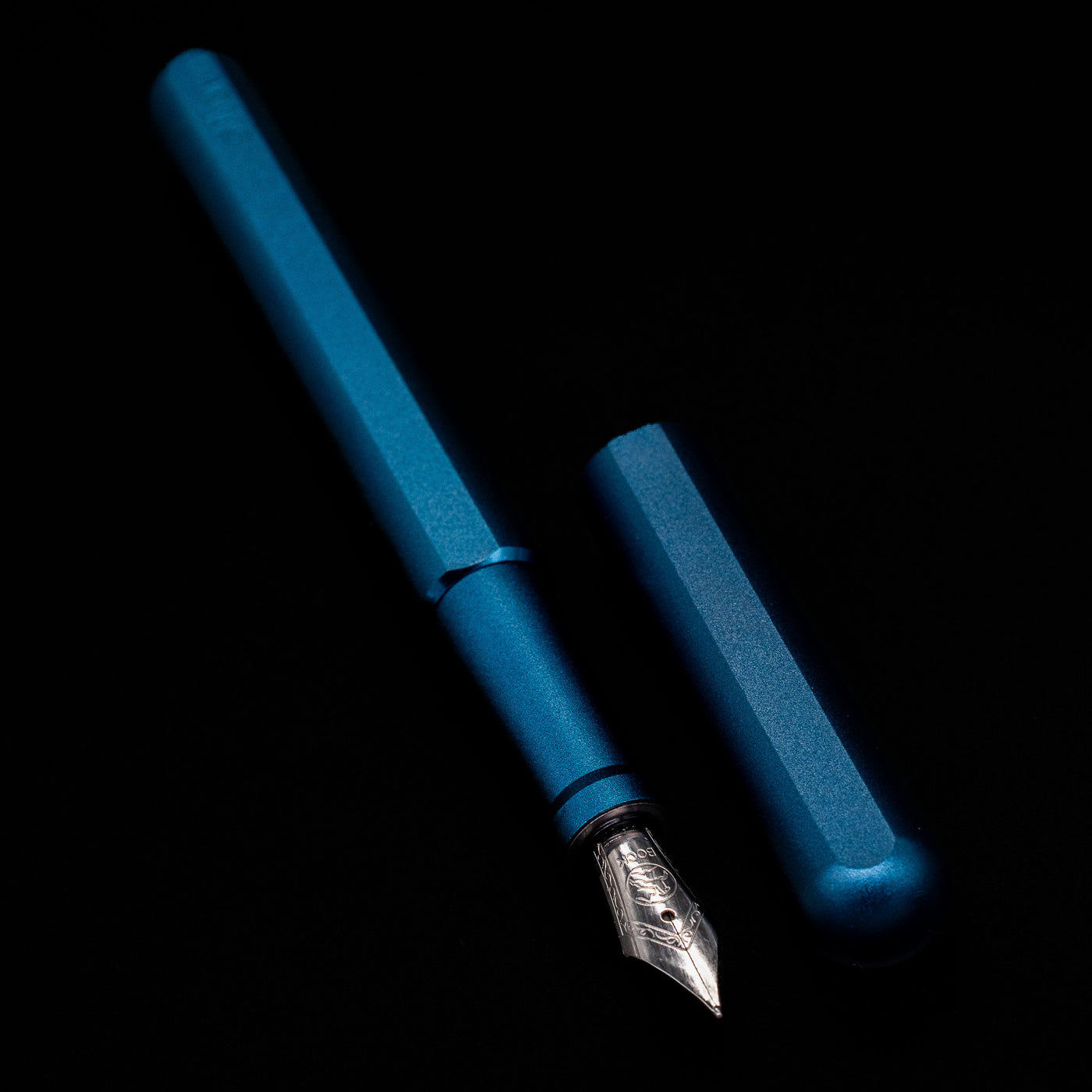 A full view of the Stilform INK Fountain Pen – Night Sky Aluminum uncapped, with its cap laying next to the pen. 
