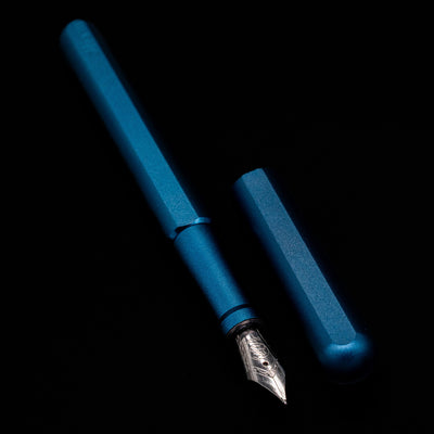 A full view of the Stilform INK Fountain Pen – Night Sky Aluminum uncapped, with its cap laying next to the pen. 