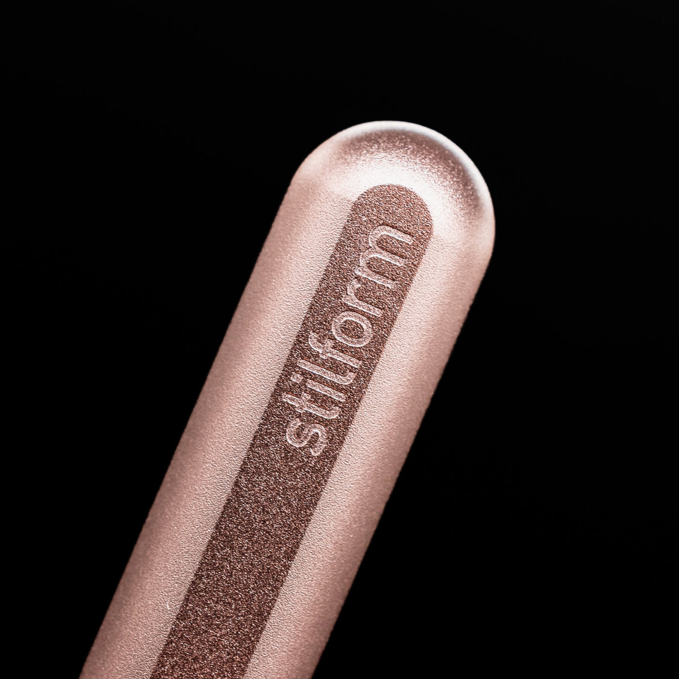 A macro shot of the logo on the bottom of the body of the Stilform INK Fountain Pen – Rose Moon Aluminum.