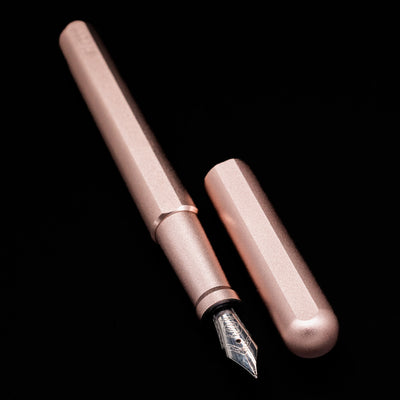 A full view of the Stilform INK Fountain Pen – Rose Moon Aluminum uncapped, with its cap laying next to the pen. 