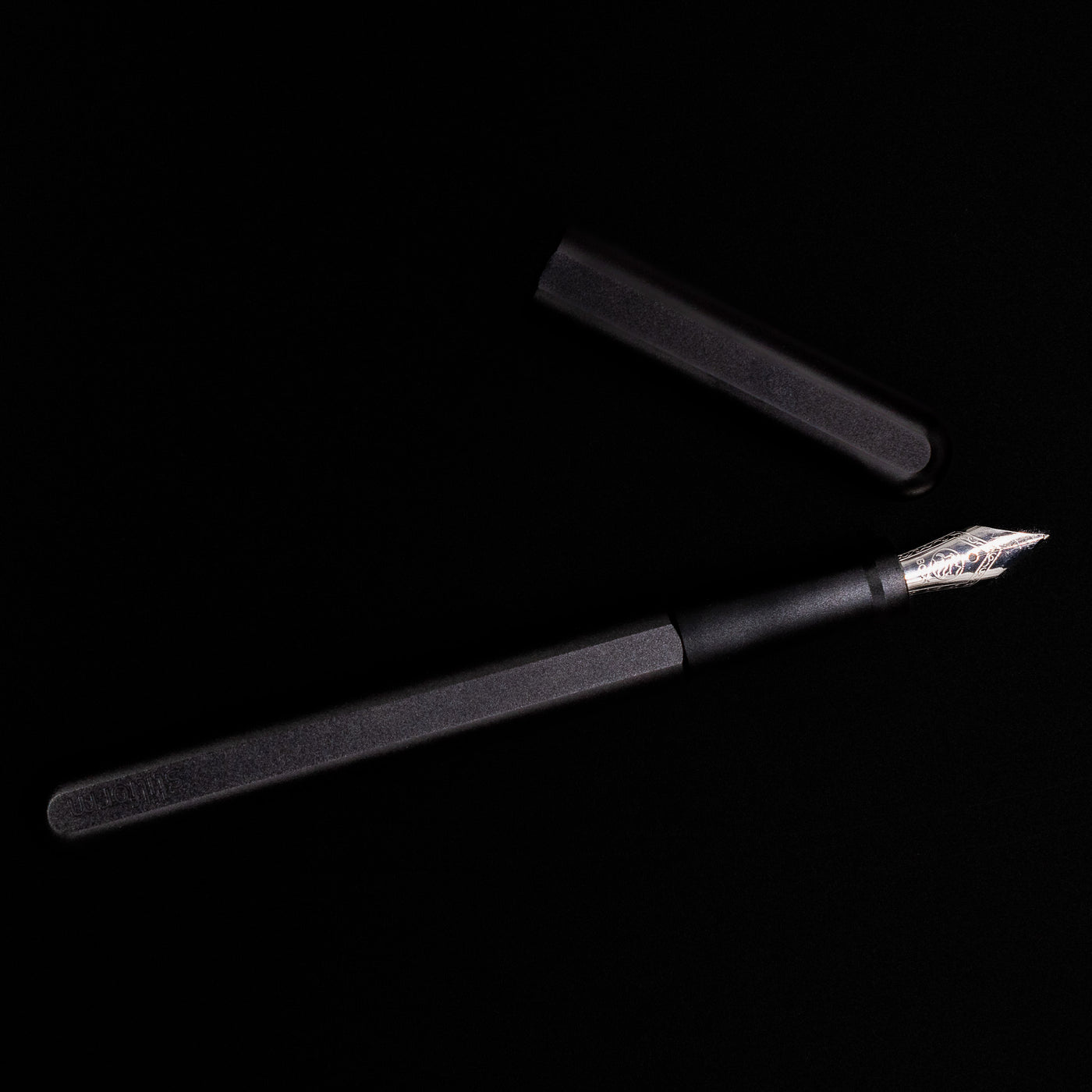 An overhead view of the Stilform INK Fountain Pen – Warp Black Aluminum uncapped.