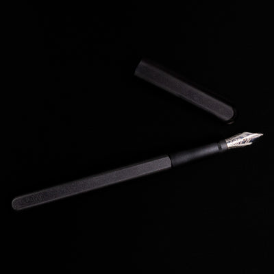 An overhead view of the Stilform INK Fountain Pen – Warp Black Aluminum uncapped.
