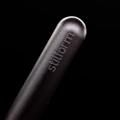 A macro shot of the logo on the cap of the Stilform PEN Ballpoint Pen – Warp Black Aluminum.
