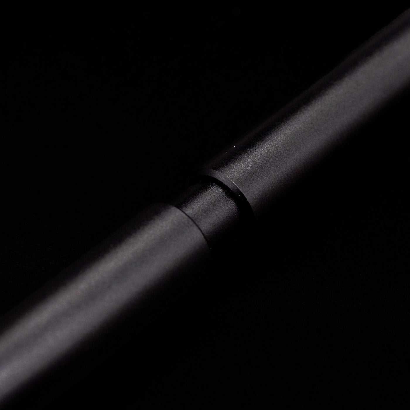 A macro shot of the part that activates the Stilform PEN Ballpoint Pen – Warp Black Aluminum.