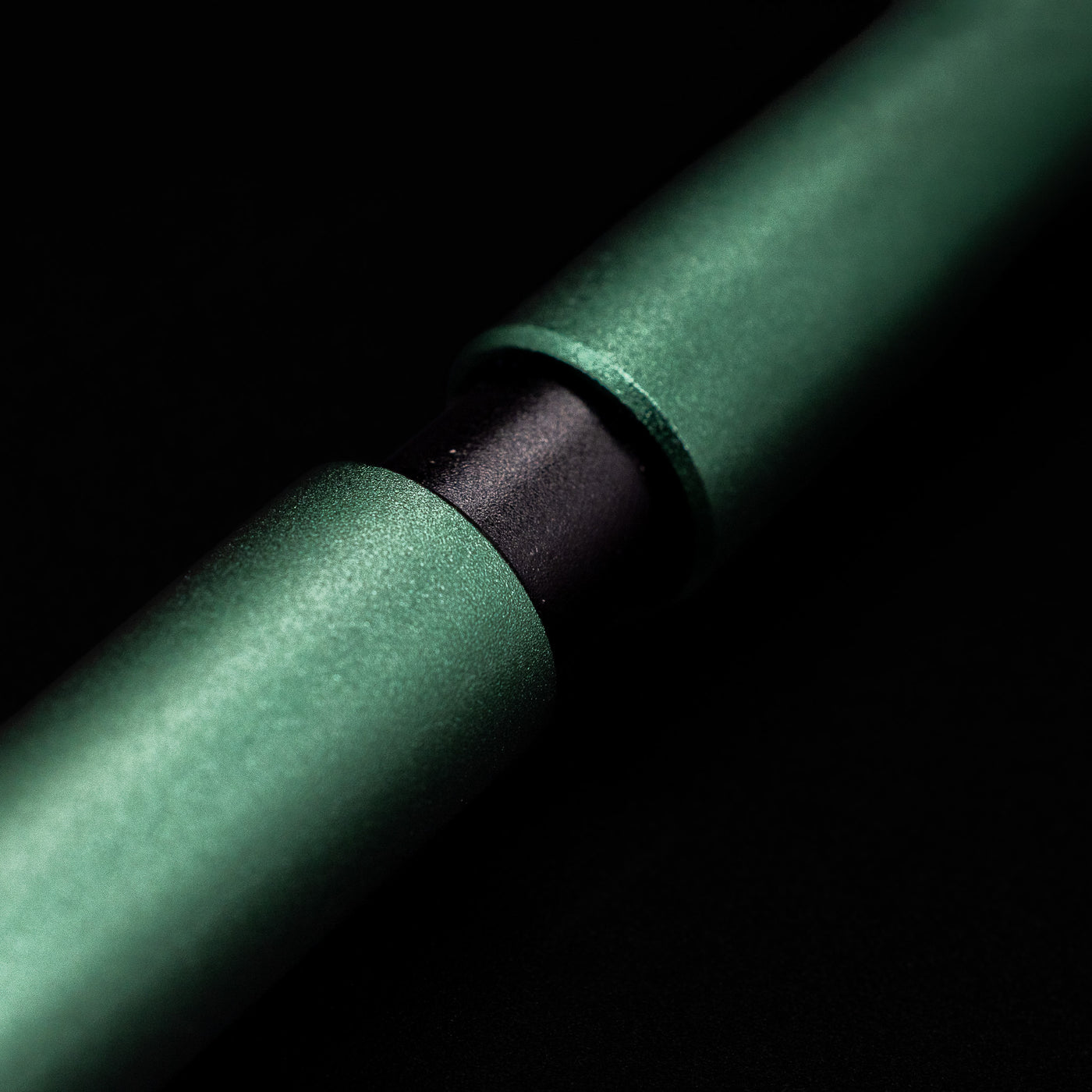 A macro shot of the part that activates the Stilform PEN Ballpoint Pen – Aurora Green Aluminum.