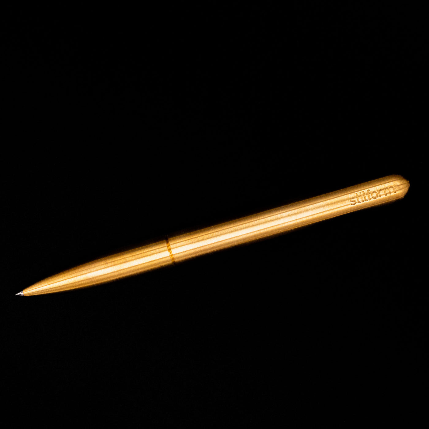 An overhead view of the Stilform PEN Ballpoint Pen – Brass Radial Brushed activated.