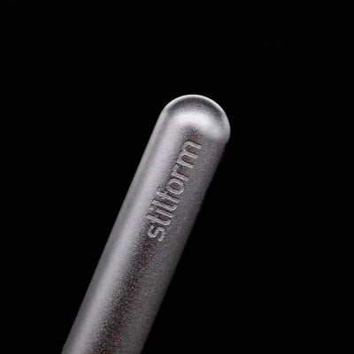 A macro shot of the logo on the cap of the Stilform PEN Ballpoint Pen – Comet Grey Aluminum.