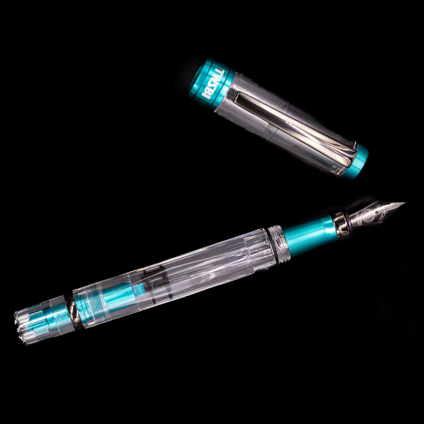 An overhead view of the TWSBI Diamond 580 Caribbean Blue & Onyx Fountain Pen - Preowned uncapped.