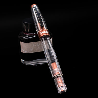 TWSBI Diamond 580ALR Affogato & Onyx Fountain Pen - Preowned capped, leaning against an ink bottle. 
