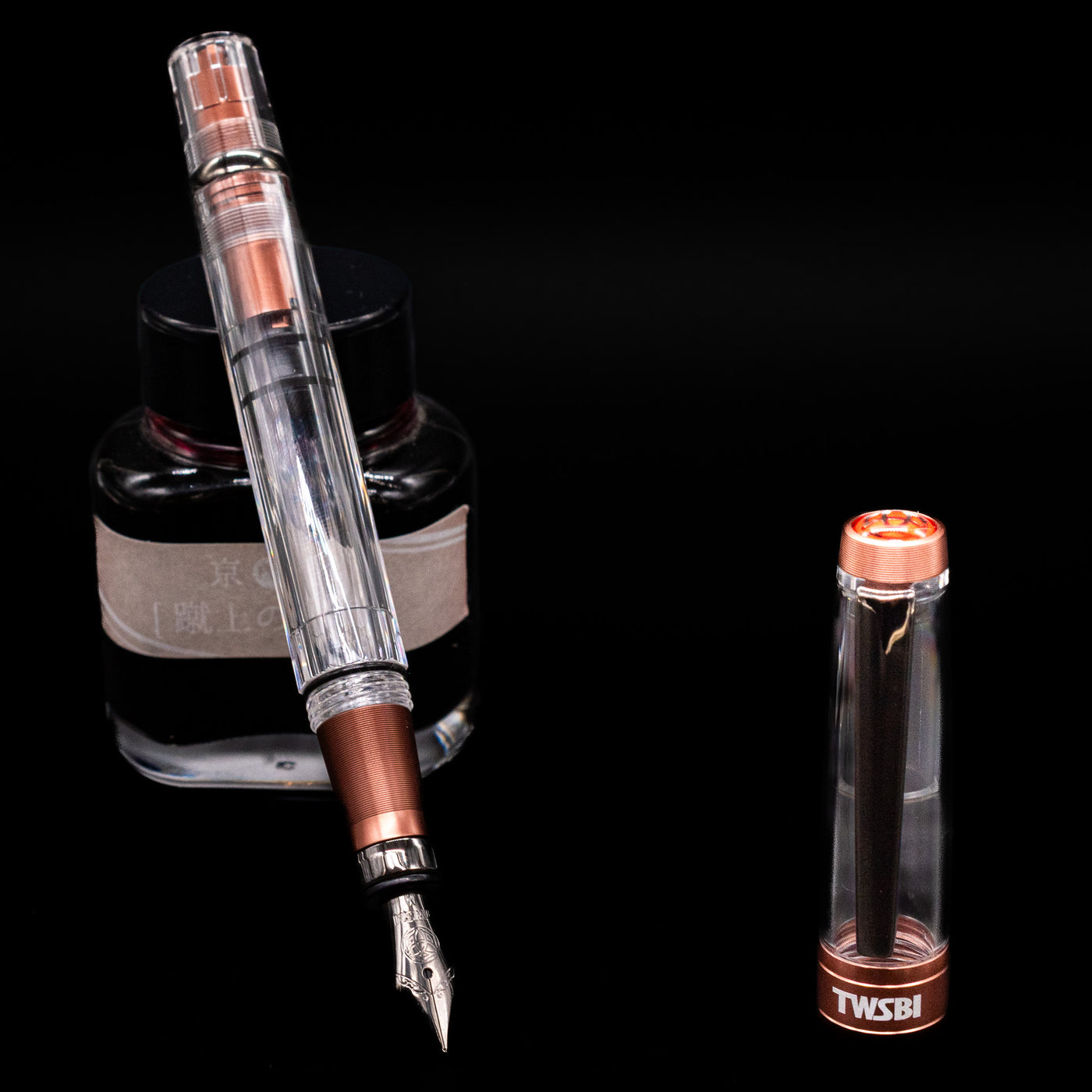 TWSBI Diamond 580ALR Affogato & Onyx Fountain Pen - Preowned leaning on an ink bottle uncapped showcasing the detailing on the nib.