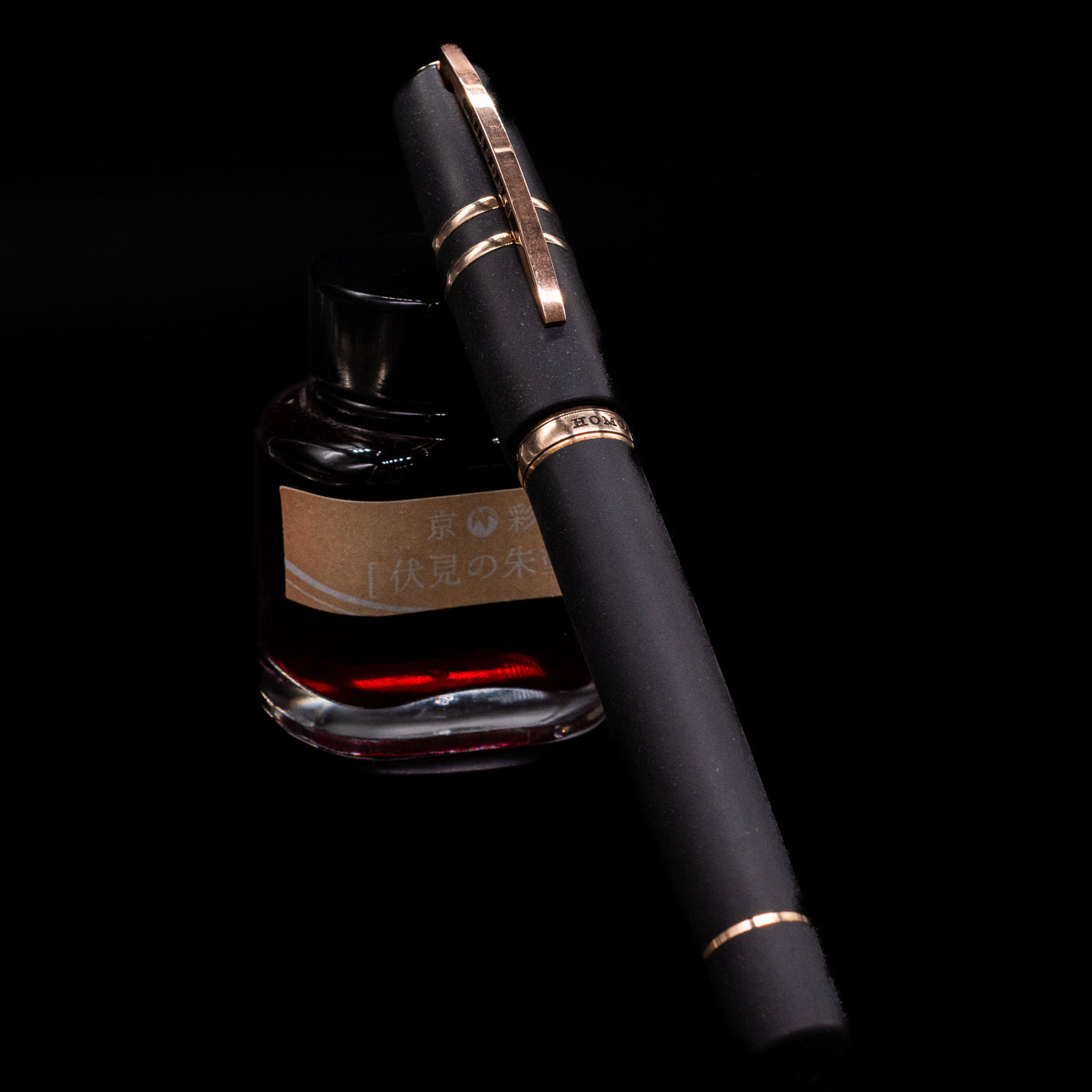 Visconti Homo Sapiens Bronze Age Fountain Pen - Architect Nib capped, leaning against an ink bottle. 