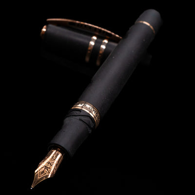 Visconti Homo Sapiens Bronze Age Fountain Pen - Architect Nib laying across its own cap, crossed, with a focus on the nib.
