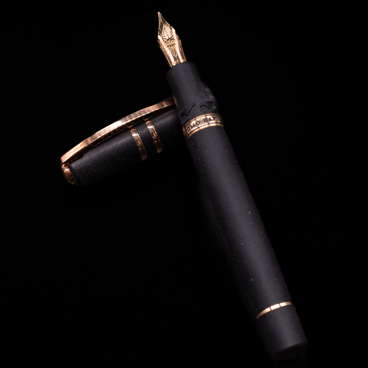 Visconti Homo Sapiens Bronze Age Fountain Pen - Architect Nib laying on top of its cap in a crossed position showing full view of the entire uncapped pen.