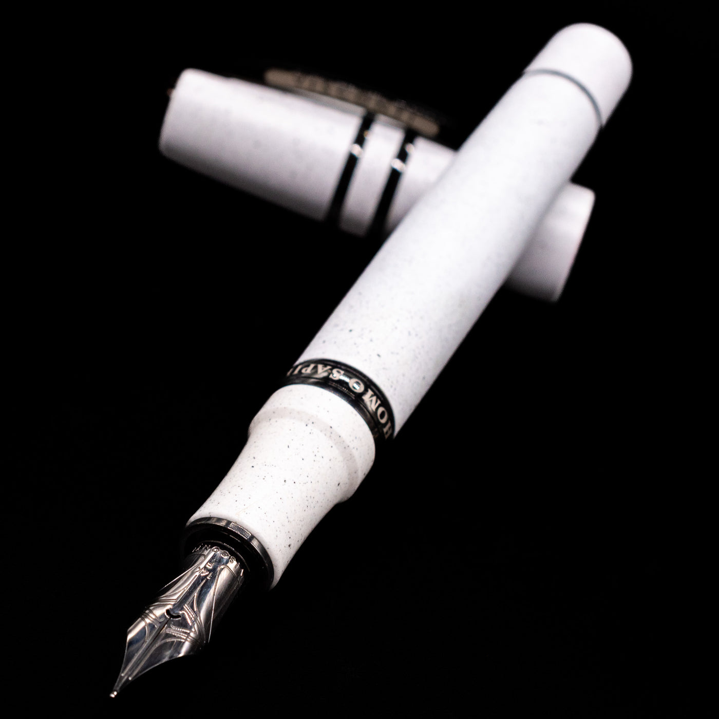 Visconti Homo Sapiens Fountain Pen - Blizzard White laying across its own cap, crossed, with a focus on the nib.