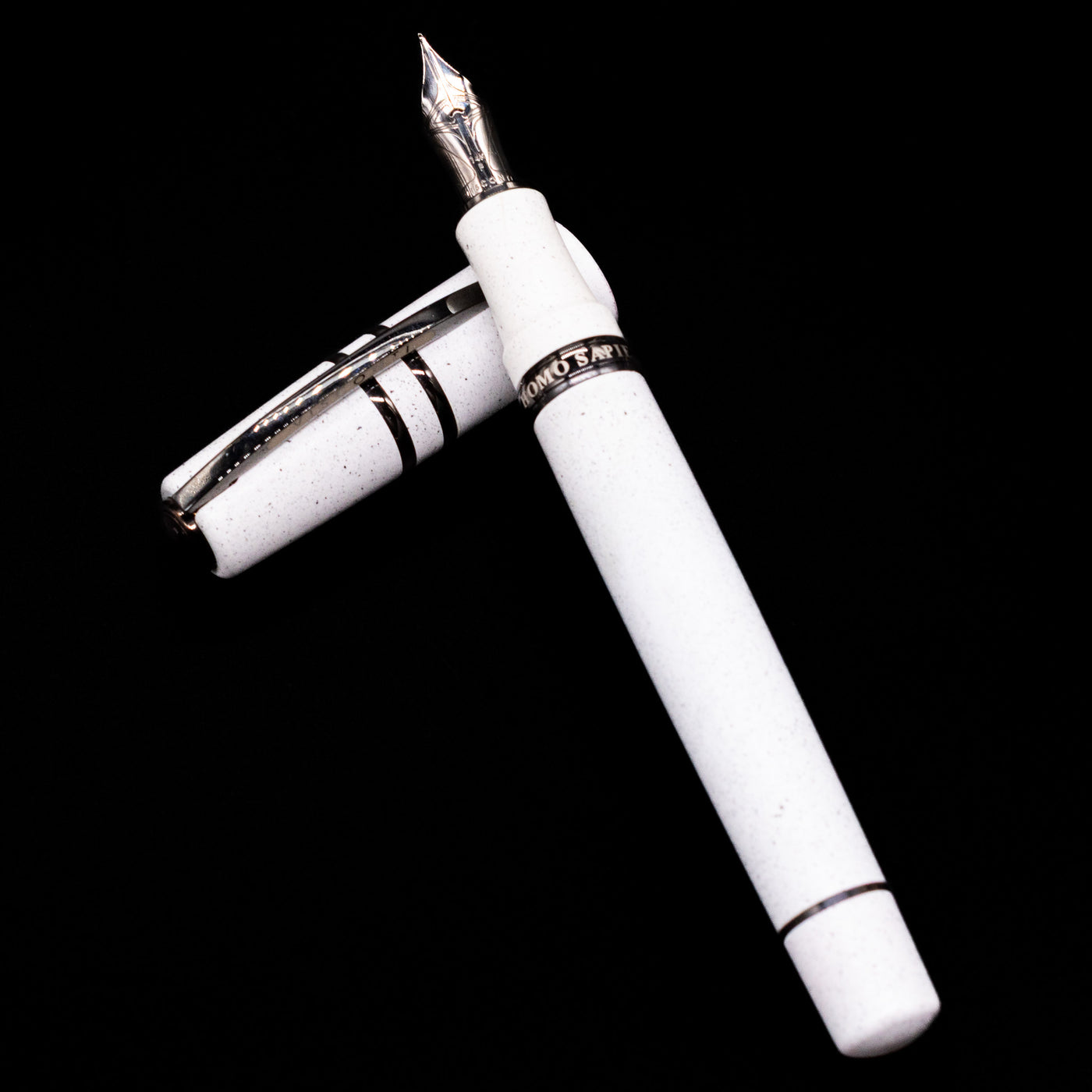 Visconti Homo Sapiens Fountain Pen - Blizzard White laying on top of its cap in a crossed position showing full view of the entire uncapped pen.