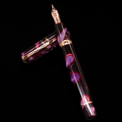 Visconti Homo Sapiens Iris Garden Fountain Pen laying on top of its cap in a crossed position showing full view of the entire uncapped pen.