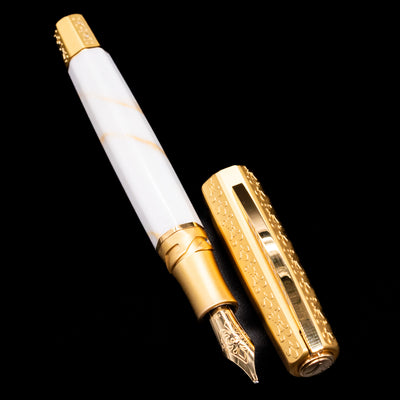 A full view of the Visconti Il Magnifico Calacatta Gold Fountain Pen uncapped, with its cap laying next to the pen. 