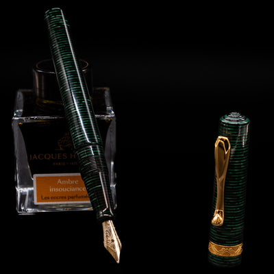 Visconti Manhattan Green Celluloid Fountain Pen - Preowned leaning on an ink bottle uncapped showcasing the detailing on the nib.