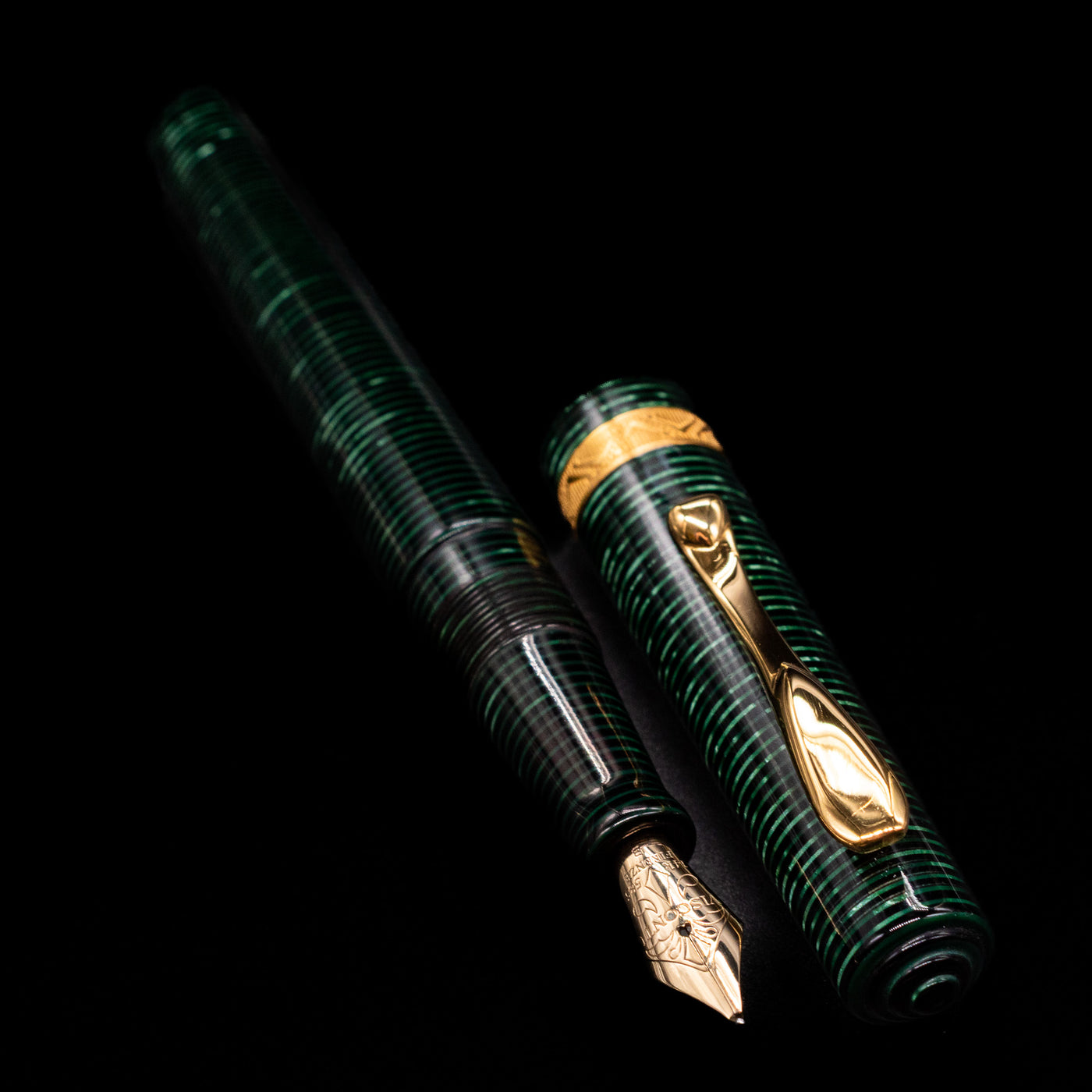 A full view of the Visconti Manhattan Green Celluloid Fountain Pen - Preowned uncapped, with its cap laying next to the pen. 