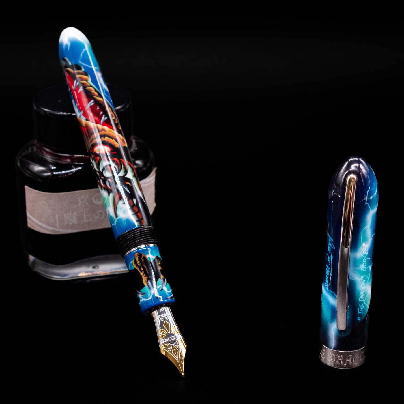 Visconti Mazzi Dragon Limited Edition Fountain Pen leaning on an ink bottle uncapped showcasing the detailing on the nib.