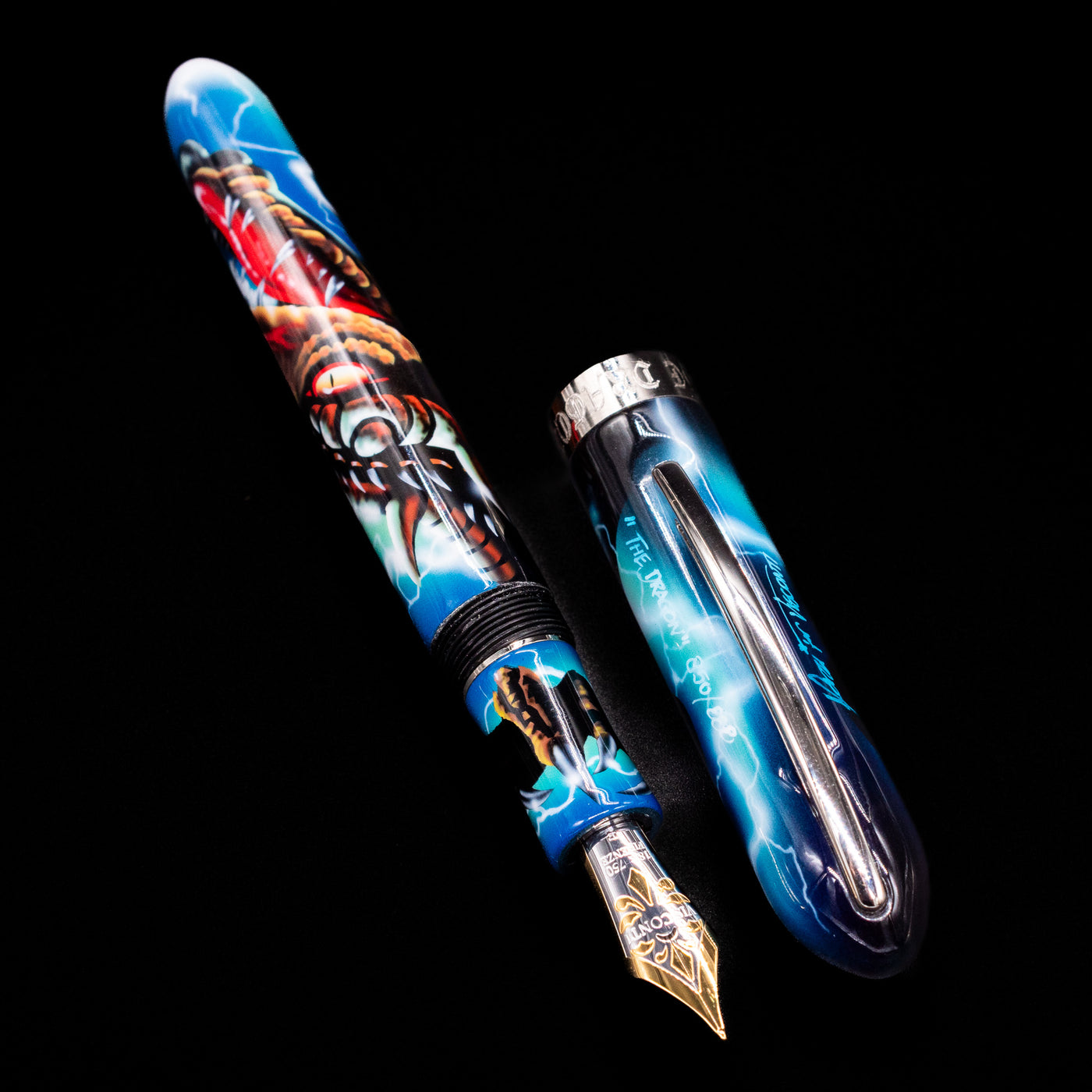 A full view of the Visconti Mazzi Dragon Limited Edition Fountain Pen uncapped, with its cap laying next to the pen.