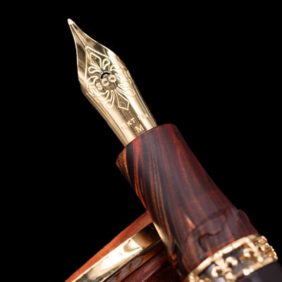 A macro shot of the 18k gold nib with the Visconti logo engraving of the Visconti Medici Briarwood Fountain Pen in Gold.