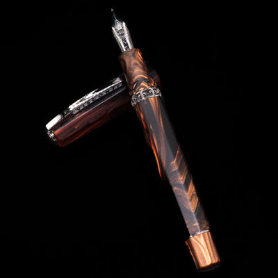 Visconti Medici Briarwood Fountain Pen in Ruthenium laying on top of its cap in a crossed position showing full view of the entire uncapped pen.