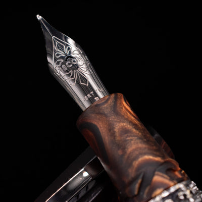 A macro shot of the 18k nib with its intricate detailing and Visconti logo engraving for the Visconti Medici Briarwood Fountain Pen in Ruthenium. 