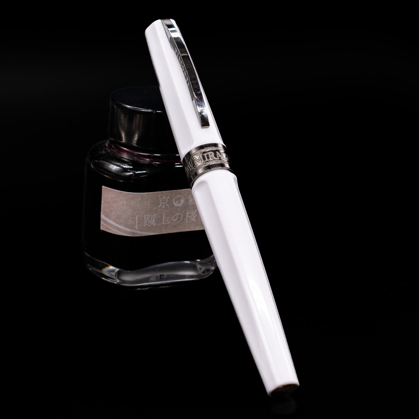 Visconti Mirage Athena Fountain Pen - Preowned capped, leaning against an ink bottle. 