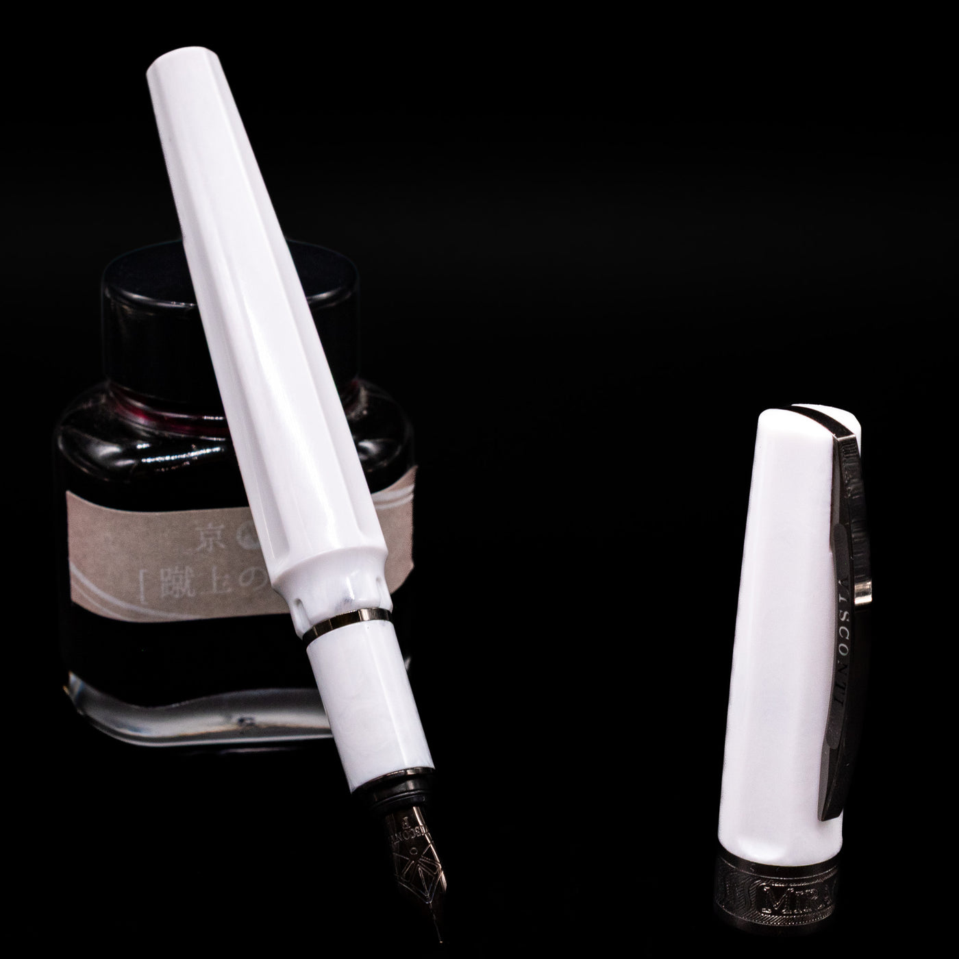 Visconti Mirage Athena Fountain Pen - Preowned leaning on an ink bottle uncapped showcasing the detailing on the nib.