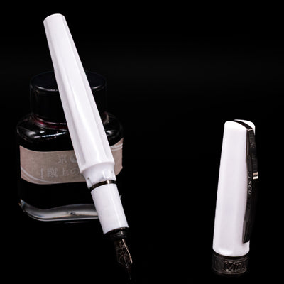 Visconti Mirage Athena Fountain Pen - Preowned leaning on an ink bottle uncapped showcasing the detailing on the nib.