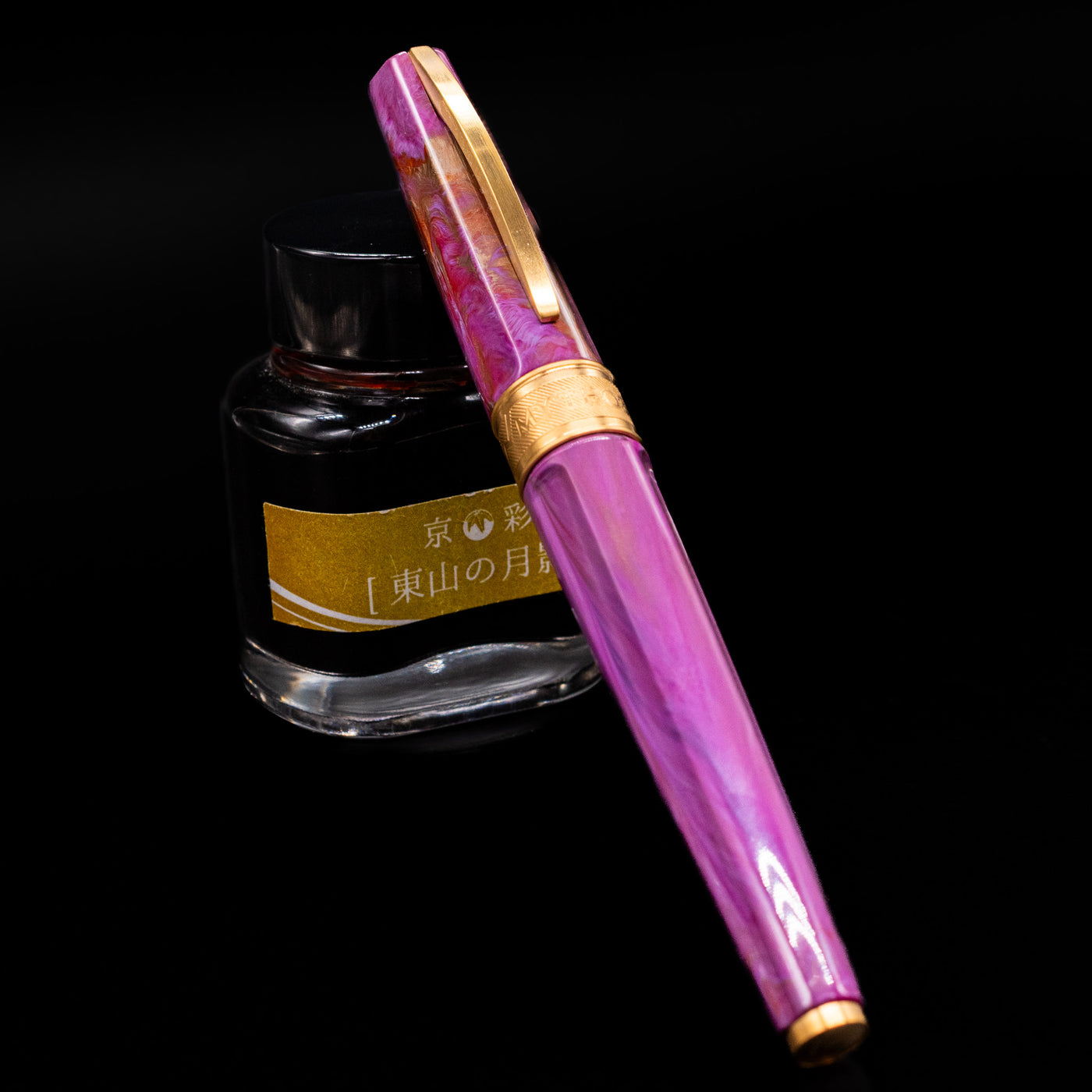 Visconti Mirage Mythos Fountain Pen - Aphrodite capped, leaning against an ink bottle. 