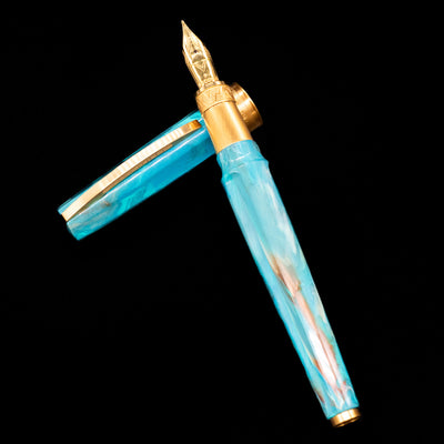 Visconti Mirage Mythos Fountain Pen - Athena laying on top of its cap in a crossed position showing full view of the entire uncapped pen.