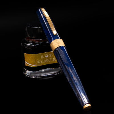 Visconti Mirage Mythos Fountain Pen - Zeus capped, leaning against an ink bottle. 