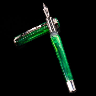 Visconti Opera Carousel Fountain Pen - Green Mint laying on top of its cap in a crossed position showing full view of the entire uncapped pen.