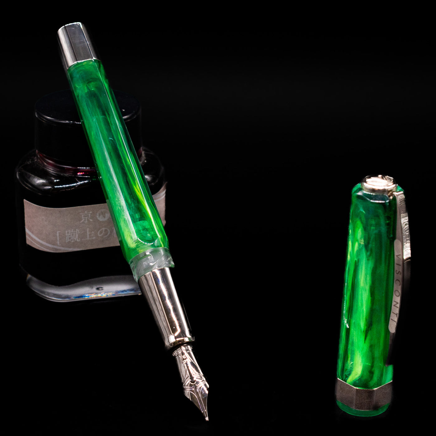Visconti Opera Carousel Fountain Pen - Green Mint leaning on an ink bottle uncapped showcasing the detailing on the nib.