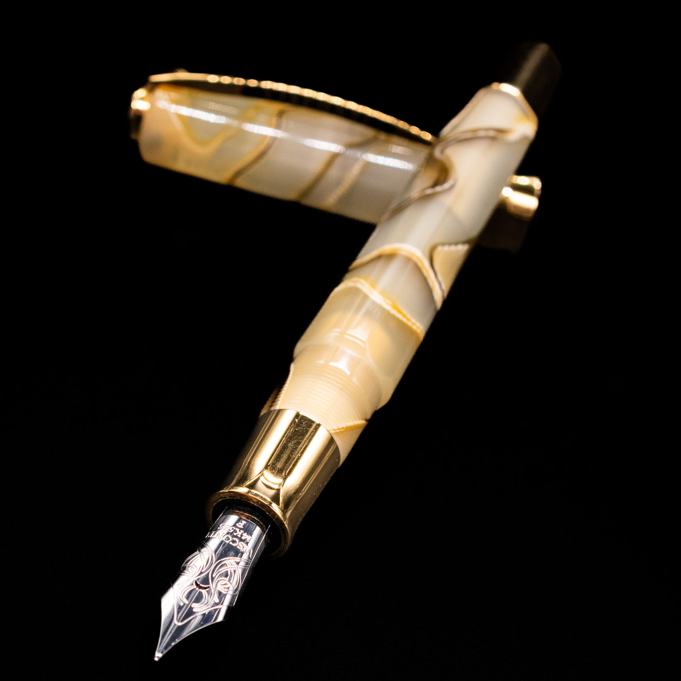 Visconti Opera Club Honey Almond Resin Fountain Pen - Preowned laying across its own cap, crossed, with a focus on the nib.