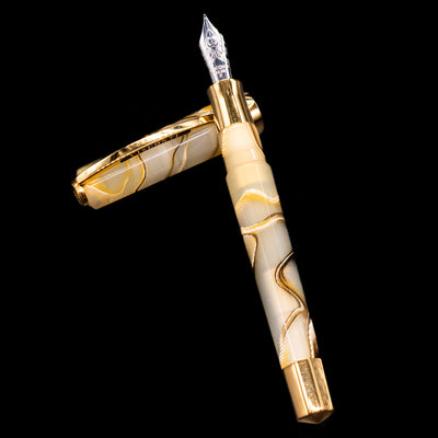 Visconti Opera Club Honey Almond Resin Fountain Pen - Preowned laying on top of its cap in a crossed position showing full view of the entire uncapped pen.