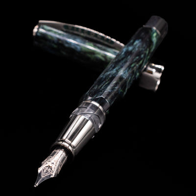 Visconti Opera Master Fountain Pen - Stargazer laying across its own cap, crossed, with a focus on the nib.