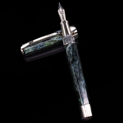 Visconti Opera Master Fountain Pen - Stargazer laying on top of its cap in a crossed position showing full view of the entire uncapped pen.