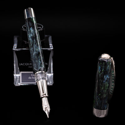 Visconti Opera Master Fountain Pen - Stargazer leaning on an ink bottle uncapped showcasing the detailing on the nib.