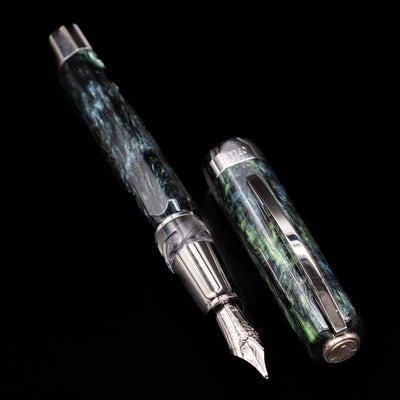 A full view of the Visconti Opera Master Fountain Pen - Stargazer uncapped, with its cap laying next to the pen. 